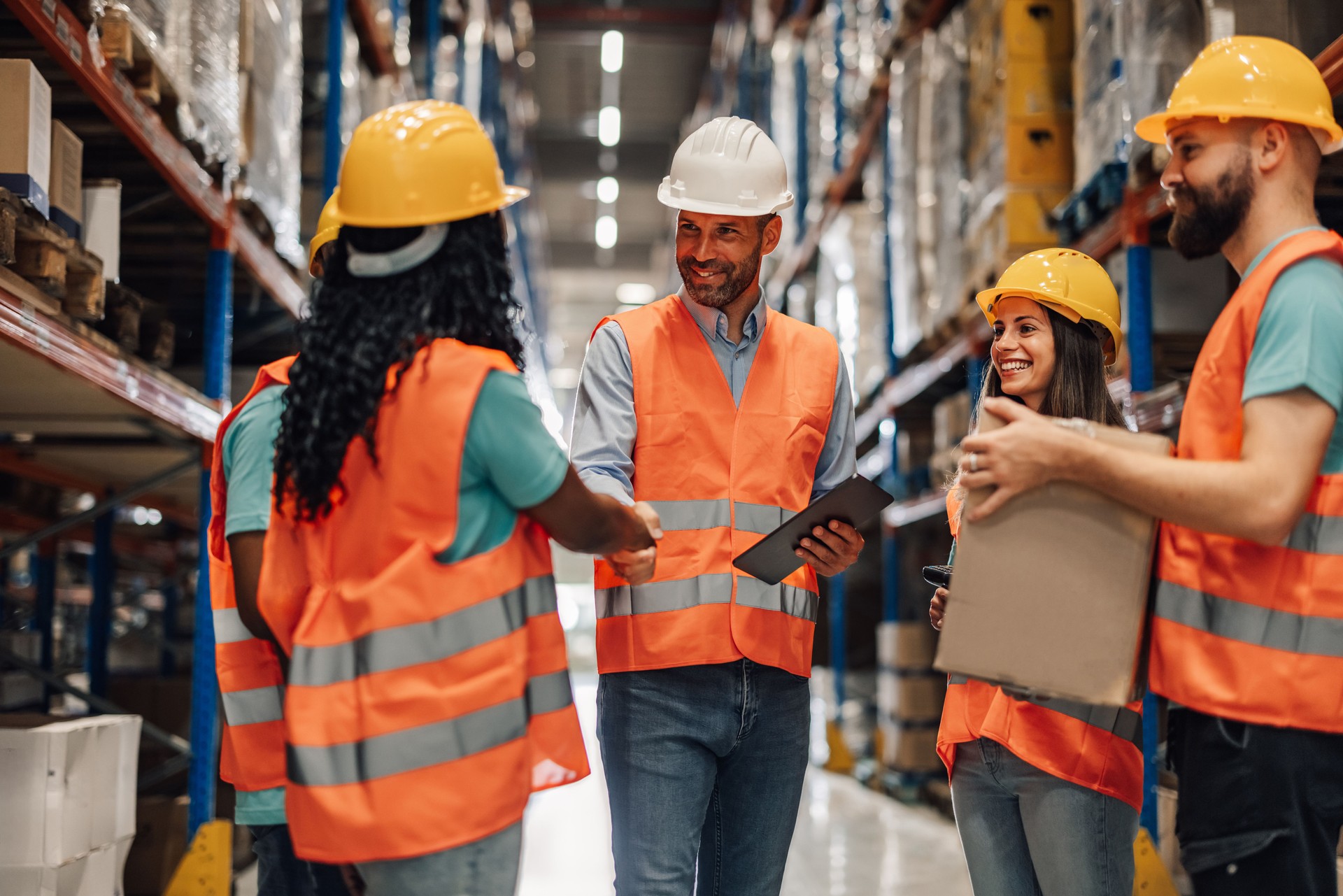 Warehouse workers greeting each other while working